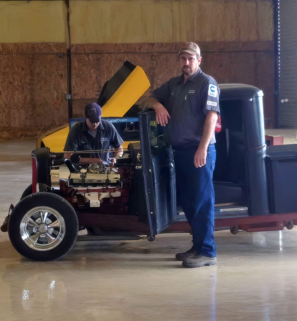 Classic car and truck repair in Hutto, TX — two mechanics working on a vintage pickup at Labor Only Auto Repair