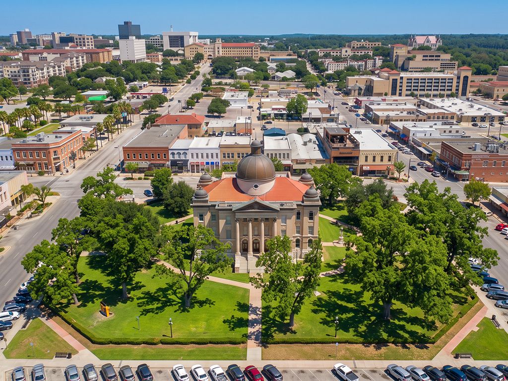 Aerial view of the crystal-clear San Marcos River winding past Texas State University in San Marcos, Texas